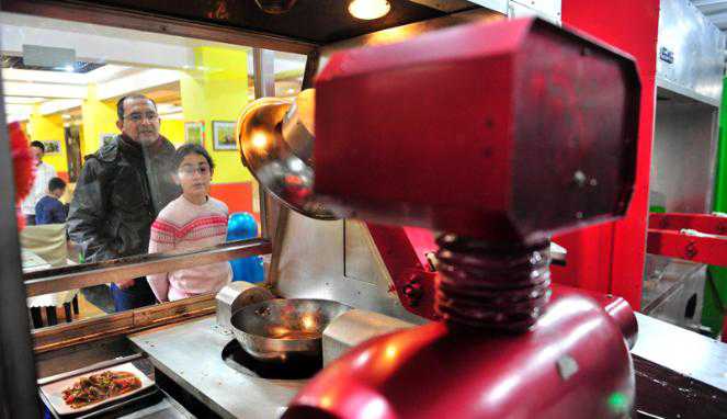 Pelanggan memperhatikan robot yang sedang memasak